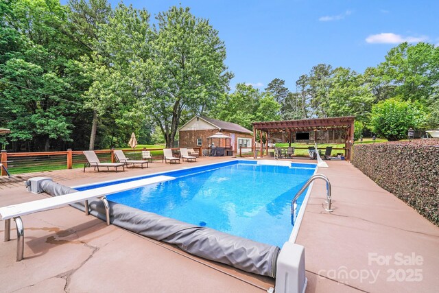 211 Drive Inn Rd, Locust, NC 28097 - view of pool with a pergola, a diving board, view of wooded area, a patio area, and an outbuilding