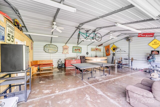 211 Drive Inn Rd, Locust, NC 28097 - garage featuring metal wall, freestanding refrigerator, and a ceiling fan