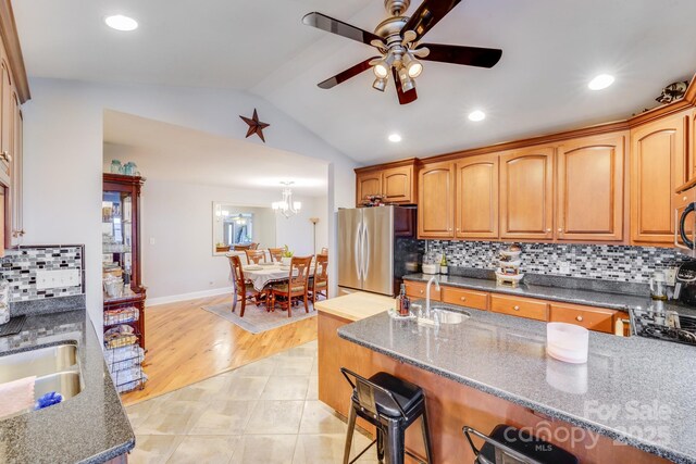 211 Drive Inn Rd, Locust, NC 28097 - kitchen featuring freestanding refrigerator, a sink, a ceiling fan, vaulted ceiling, and a breakfast bar