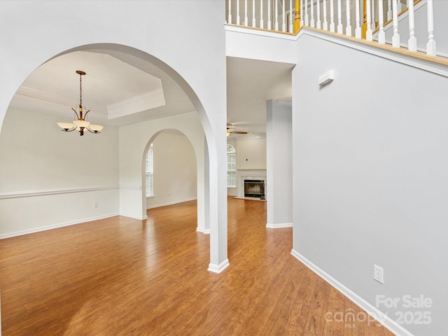 12529 Old Timber Rd, Charlotte, NC 28269 - entrance foyer with ceiling fan, light wood finished floors, a chandelier, baseboards, and arched walkways