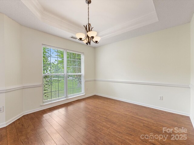 12529 Old Timber Rd, Charlotte, NC 28269 - spare room featuring a raised ceiling, a chandelier, ornamental molding, hardwood / wood-style flooring, and baseboards