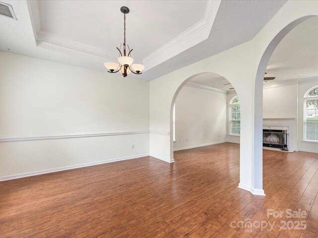 12529 Old Timber Rd, Charlotte, NC 28269 - empty room featuring a chandelier, hardwood / wood-style floors, ornamental molding, a tray ceiling, and a premium fireplace