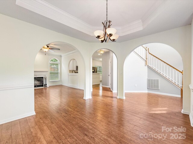 12529 Old Timber Rd, Charlotte, NC 28269 - unfurnished living room with a raised ceiling, hardwood / wood-style floors, ceiling fan, a chandelier, and ornamental molding