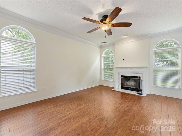 12529 Old Timber Rd, Charlotte, NC 28269 - unfurnished living room featuring wood-type flooring, ceiling fan, a fireplace, ornamental molding, and a textured ceiling