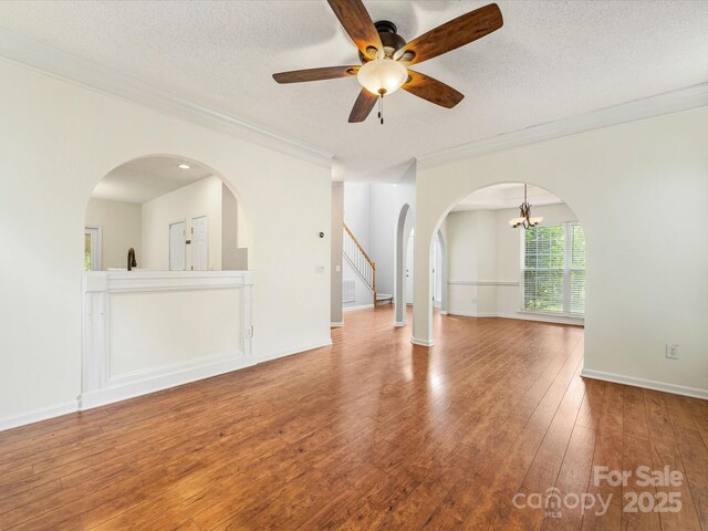 12529 Old Timber Rd, Charlotte, NC 28269 - unfurnished living room with ornamental molding, hardwood / wood-style floors, ceiling fan, a chandelier, and arched walkways