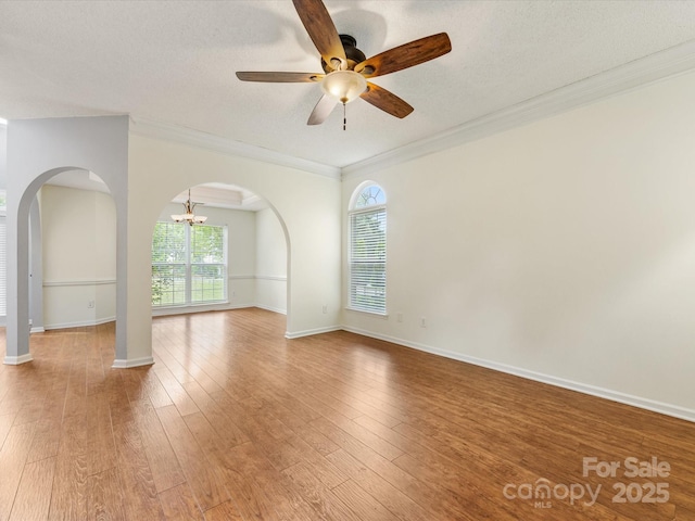 12529 Old Timber Rd, Charlotte, NC 28269 - spare room featuring arched walkways, crown molding, ceiling fan, light wood-type flooring, and baseboards