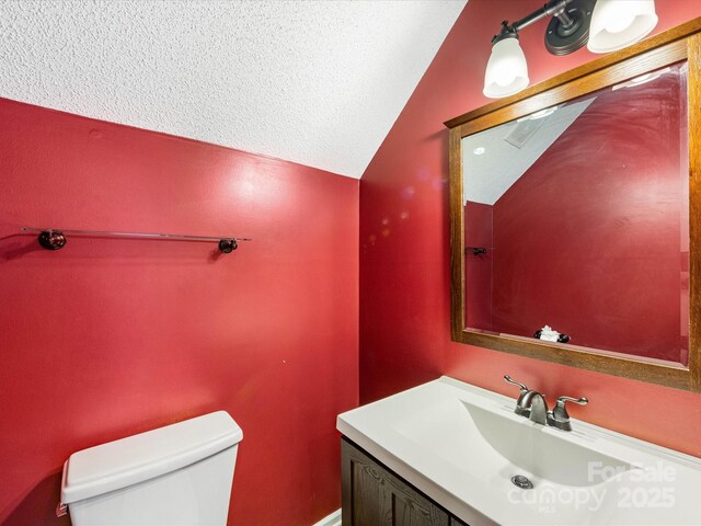 12529 Old Timber Rd, Charlotte, NC 28269 - bathroom with lofted ceiling, toilet, vanity, and a textured ceiling