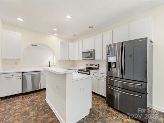 12529 Old Timber Rd, Charlotte, NC 28269 - kitchen featuring stainless steel appliances, light countertops, white cabinets, arched walkways, and recessed lighting