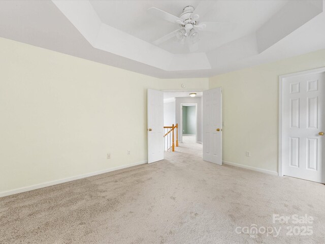 12529 Old Timber Rd, Charlotte, NC 28269 - unfurnished room featuring a tray ceiling, light carpet, ceiling fan, and baseboards