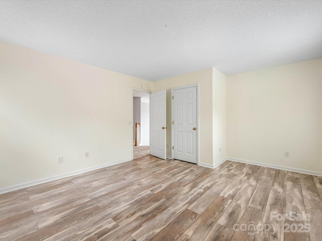 12529 Old Timber Rd, Charlotte, NC 28269 - unfurnished room with light wood-style floors, baseboards, and a textured ceiling