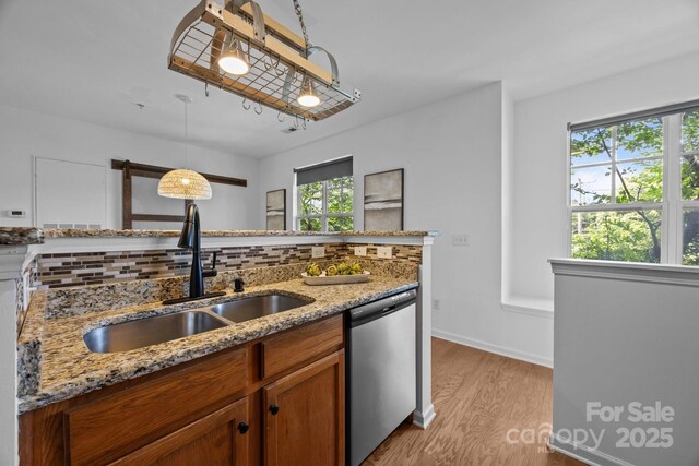 1556 Walnut View Dr, Charlotte, NC 28208 - kitchen featuring dishwasher, brown cabinetry, backsplash, light wood finished floors, and hanging light fixtures