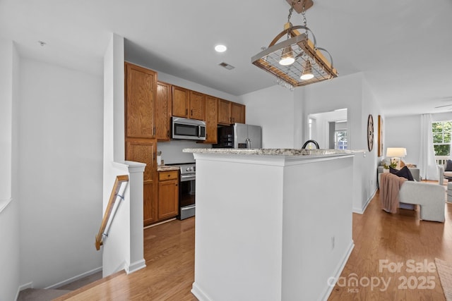 1556 Walnut View Dr, Charlotte, NC 28208 - kitchen with appliances with stainless steel finishes, light wood finished floors, and brown cabinets