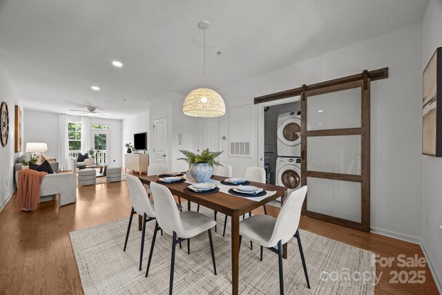 1556 Walnut View Dr, Charlotte, NC 28208 - dining area with stacked washer and clothes dryer, a barn door, wood finished floors, recessed lighting, and a ceiling fan