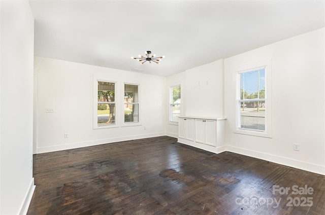 1112 Concord Ave, Monroe, NC 28110 - spare room featuring healthy amount of natural light, a chandelier, dark wood-style flooring, and baseboards