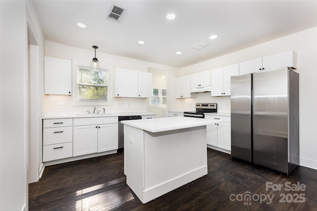 1112 Concord Ave, Monroe, NC 28110 - kitchen with stainless steel appliances, white cabinets, light countertops, a sink, and a center island