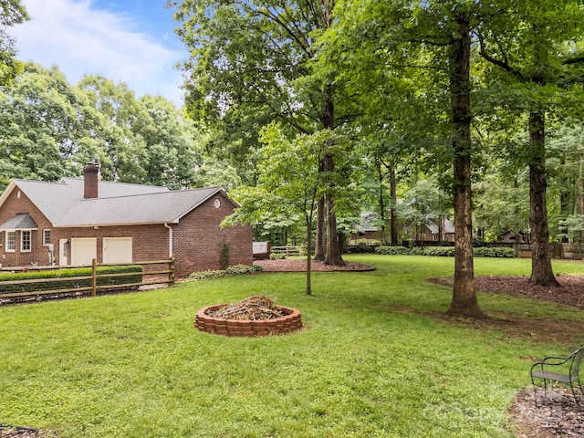 635 Timberlane Trl, Salisbury, NC 28147 - view of yard with an attached garage, an outdoor fire pit, and view of wooded area