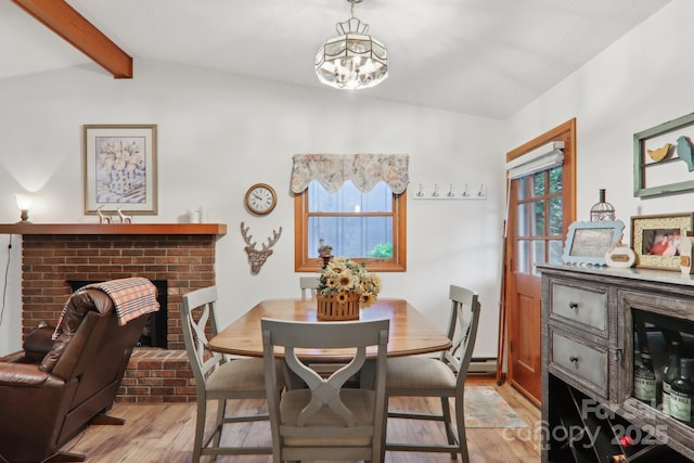 418 Stoney Ridge Loop, Maggie Valley, NC 28751 - dining area featuring wood finished floors, a chandelier, a brick fireplace, and baseboard heating