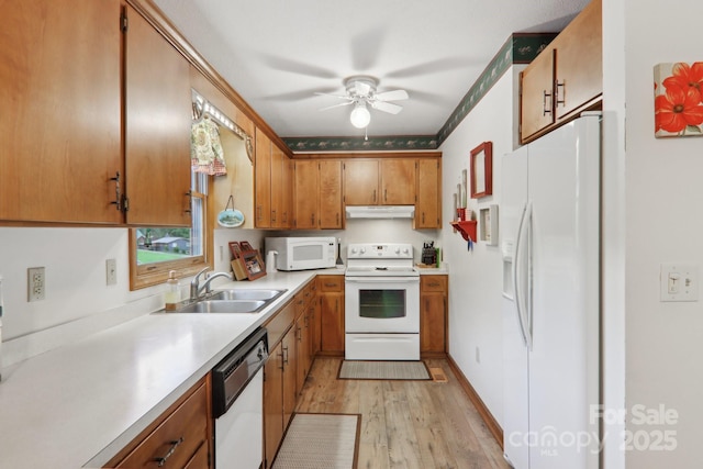 418 Stoney Ridge Loop, Maggie Valley, NC 28751 - kitchen featuring white appliances, under cabinet range hood, a sink, brown cabinetry, and light wood-style floors