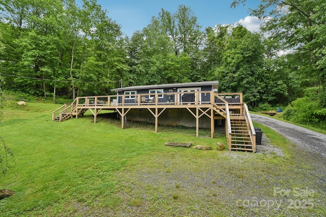 72 Wakulla Dr, Maggie Valley, NC 28751 - back of house with stairs, a deck, a wooded view, and a yard