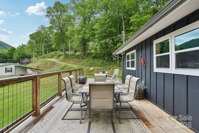 72 Wakulla Dr, Maggie Valley, NC 28751 - deck featuring outdoor dining area, a lawn, and a wooded view
