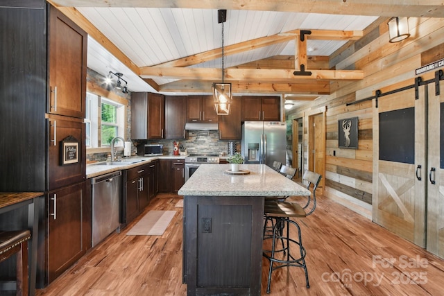 72 Wakulla Dr, Maggie Valley, NC 28751 - kitchen featuring stainless steel appliances, a sink, light wood finished floors, a kitchen island, and wooden walls