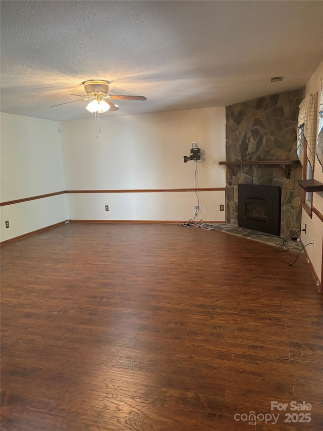 550 Camrose Cir NE, Concord, NC 28025 - unfurnished living room featuring wood finished floors, a ceiling fan, baseboards, a fireplace, and a textured ceiling