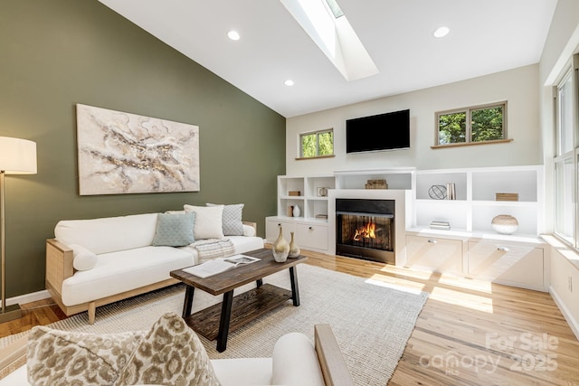 506 Hiawassee Ave, Black Mountain, NC 28711 - living area featuring a glass covered fireplace, healthy amount of natural light, a skylight, light wood-type flooring, and high vaulted ceiling