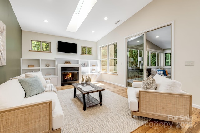 506 Hiawassee Ave, Black Mountain, NC 28711 - living room featuring lofted ceiling, wood finished floors, a glass covered fireplace, a skylight, and baseboards