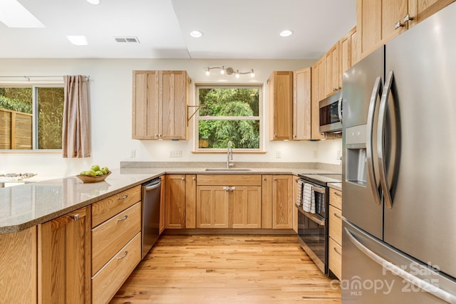 506 Hiawassee Ave, Black Mountain, NC 28711 - kitchen featuring appliances with stainless steel finishes, a sink, light wood finished floors, light brown cabinets, and light stone countertops