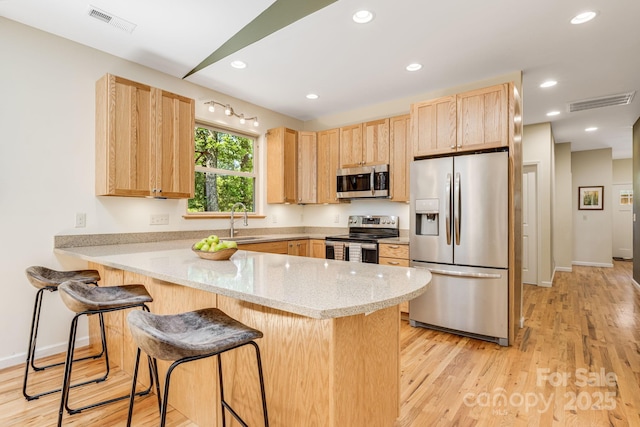 506 Hiawassee Ave, Black Mountain, NC 28711 - kitchen with appliances with stainless steel finishes, light brown cabinets, a sink, a peninsula, and a breakfast bar area