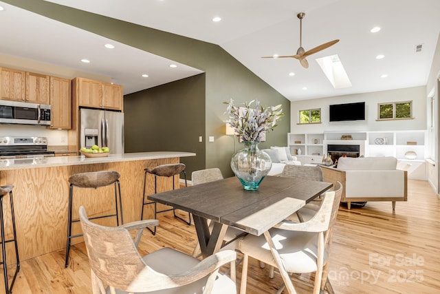 506 Hiawassee Ave, Black Mountain, NC 28711 - dining room featuring a skylight, light wood-style floors, lofted ceiling, a fireplace, and recessed lighting