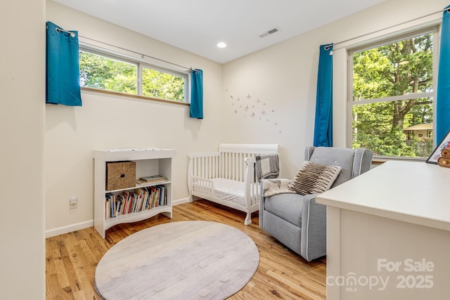 506 Hiawassee Ave, Black Mountain, NC 28711 - bedroom with multiple windows, light wood-type flooring, baseboards, a crib, and recessed lighting