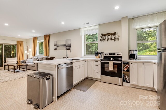 506 Hiawassee Ave, Black Mountain, NC 28711 - kitchen featuring appliances with stainless steel finishes, a sink, recessed lighting, light wood-style flooring, and white cabinetry