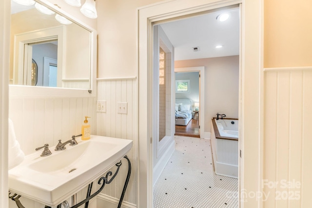 24 Warwick Rd, Asheville, NC 28803 - bathroom with a wainscoted wall, a sink, and a bathtub