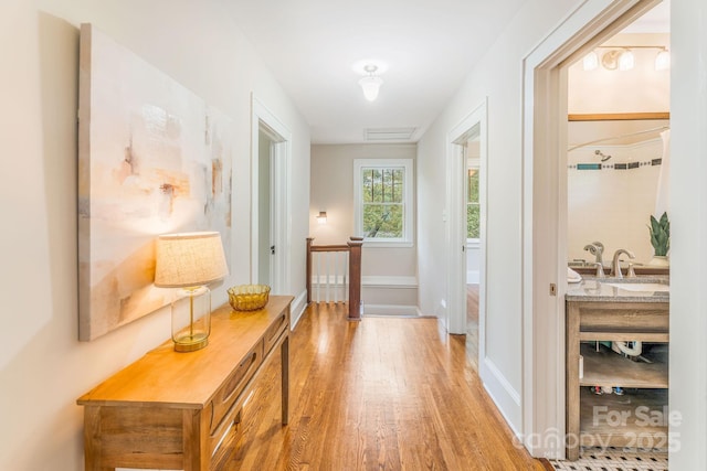 24 Warwick Rd, Asheville, NC 28803 - hall with an upstairs landing, light wood finished floors, a sink, and baseboards