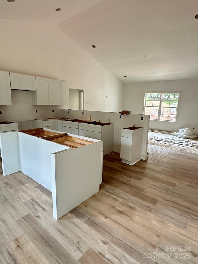63 Cornerstone Dr, Taylorsville, NC 28681 - kitchen featuring light wood-style flooring, white cabinets, and high vaulted ceiling