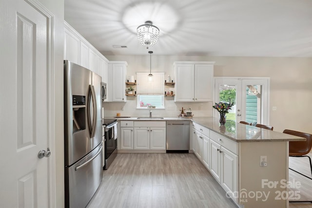7931 Baylis Dr, Huntersville, NC 28078 - kitchen featuring stainless steel appliances, a peninsula, a sink, and white cabinets