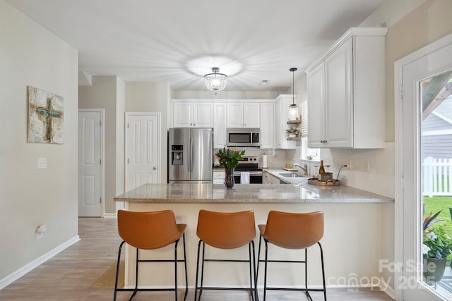 7931 Baylis Dr, Huntersville, NC 28078 - kitchen with stainless steel appliances, a sink, a peninsula, decorative backsplash, and white cabinetry