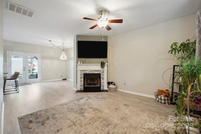 7931 Baylis Dr, Huntersville, NC 28078 - unfurnished living room with wood finished floors, ceiling fan, baseboards, and a stone fireplace