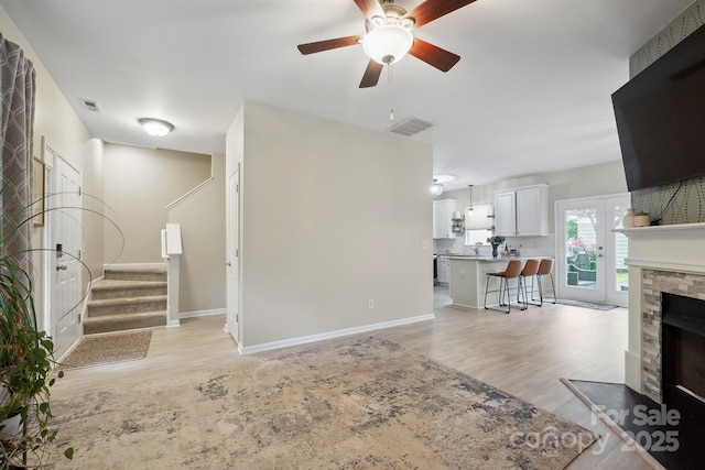 7931 Baylis Dr, Huntersville, NC 28078 - living room with ceiling fan, a fireplace, light wood finished floors, and baseboards