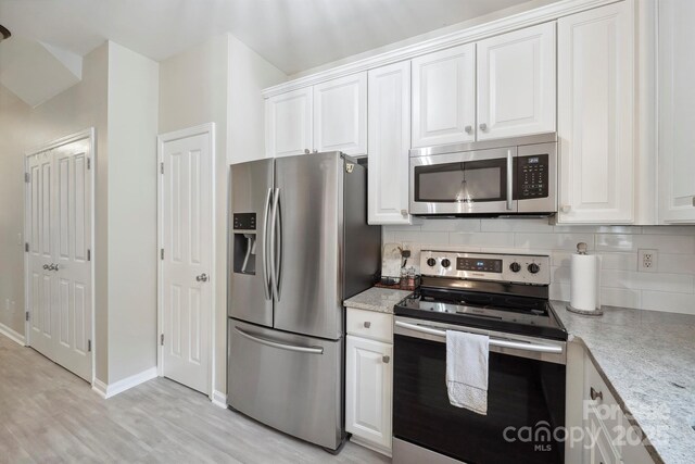 7931 Baylis Dr, Huntersville, NC 28078 - kitchen featuring appliances with stainless steel finishes, decorative backsplash, white cabinetry, light wood-type flooring, and baseboards