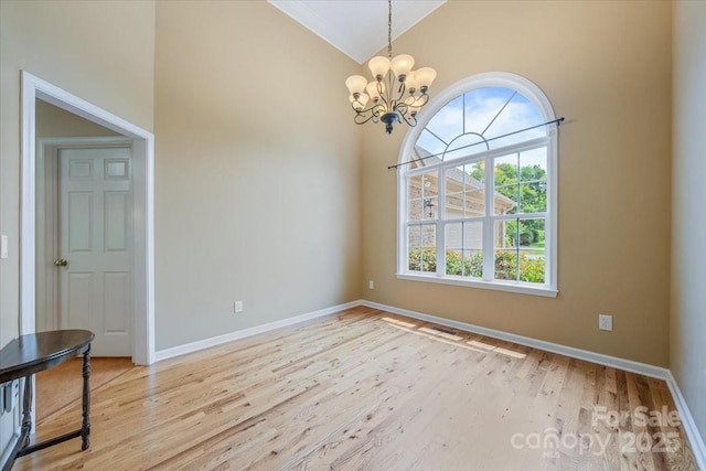 305 River Birch Cir, Mooresville, NC 28115 - spare room with wood finished floors, a chandelier, baseboards, and high vaulted ceiling
