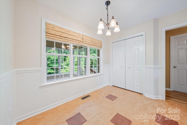 305 River Birch Cir, Mooresville, NC 28115 - unfurnished bedroom with a wainscoted wall, a chandelier, multiple windows, and a closet