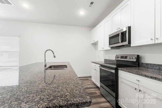 1112 Angle St, Cherryville, NC 28021 - kitchen featuring appliances with stainless steel finishes, a sink, dark wood-style floors, white cabinets, and dark stone countertops