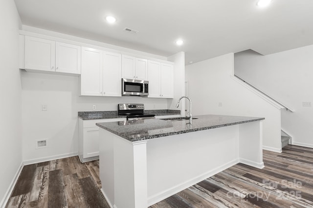 1112 Angle St, Cherryville, NC 28021 - kitchen featuring appliances with stainless steel finishes, a sink, dark wood-type flooring, dark stone countertops, and white cabinetry