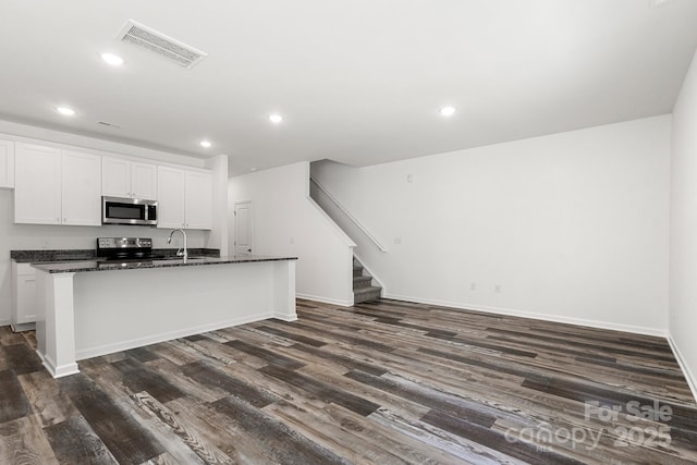 1112 Angle St, Cherryville, NC 28021 - kitchen with appliances with stainless steel finishes, dark wood-style flooring, a kitchen island with sink, white cabinets, and recessed lighting