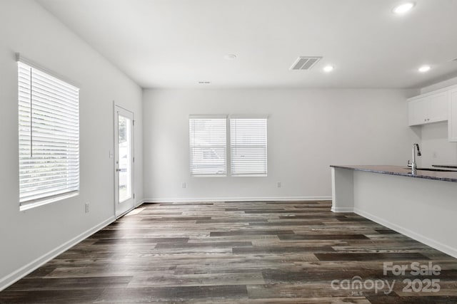 1112 Angle St, Cherryville, NC 28021 - unfurnished living room with dark wood-type flooring, recessed lighting, a sink, and baseboards