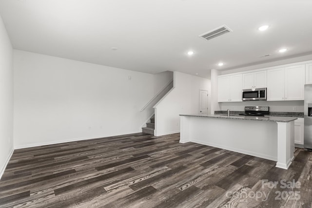 1112 Angle St, Cherryville, NC 28021 - kitchen with appliances with stainless steel finishes, dark wood-type flooring, recessed lighting, a center island with sink, and white cabinets