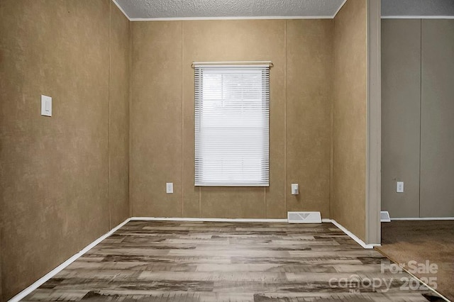 203 Bethlehem Church Rd, Grover, NC 28073 - spare room featuring wood finished floors, a textured ceiling, and ornamental molding