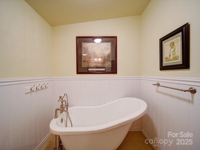 157 Old Hearth Rd, Clover, SC 29710 - bathroom with a freestanding bath, a wainscoted wall, and tile patterned floors